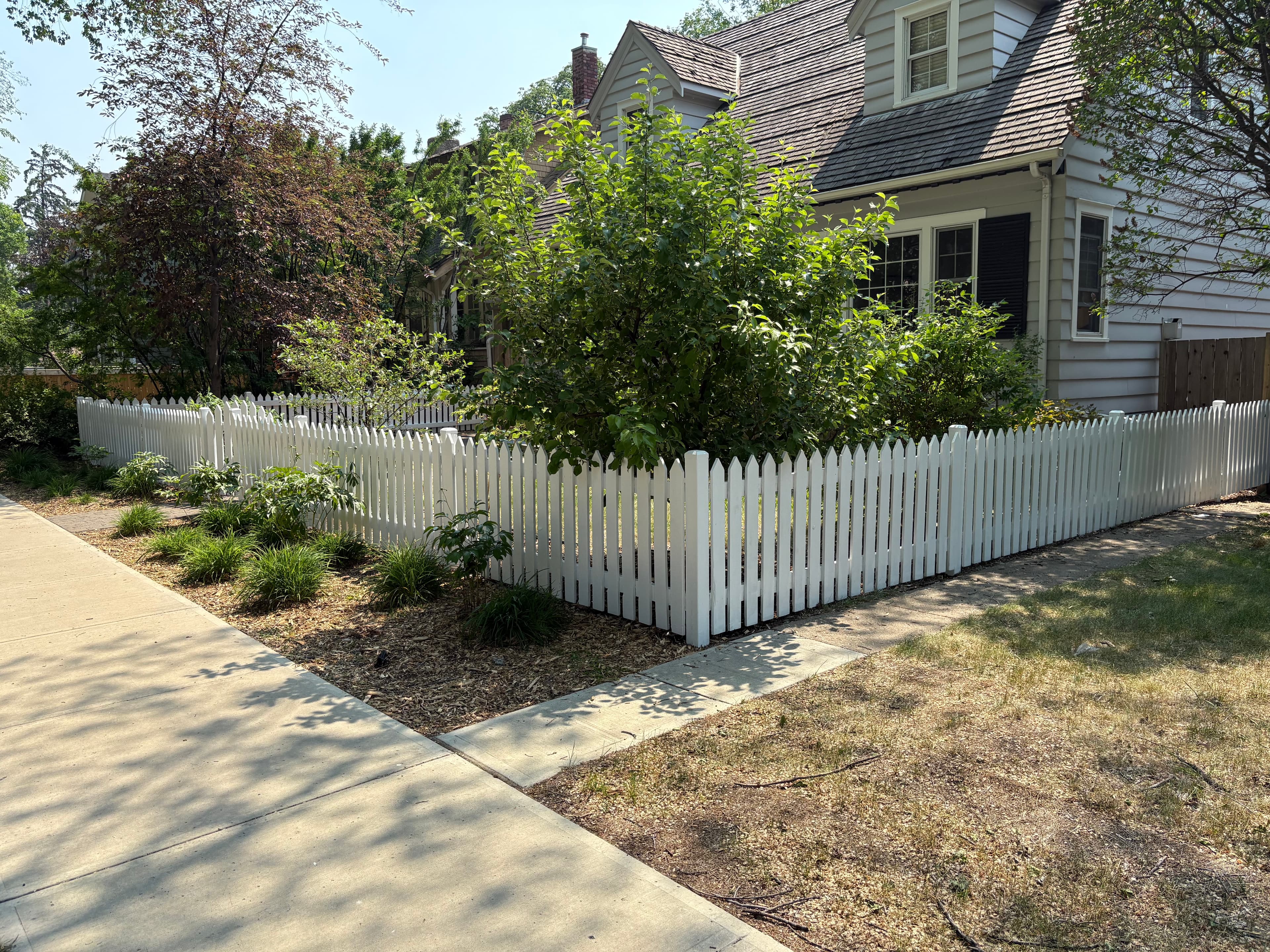 Wooden picket fence after professional exterior finishing